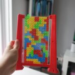 Joc de inteligenta Tetris puzzle tangram Embo, 70 de piese multicolore, 3D, montessori, interactiv, din plastic, zar inclus, sac depozitare piese, varsta peste 6 ani, 23 x 19.8 x 5 cm, cadru rosu - imagine 9